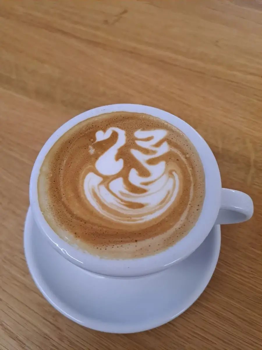 Cappuccino mit Latte Art in Schwanform